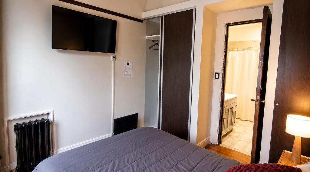 Vista general de la habitación con TV y entrada al baño privado